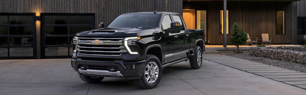 Black Chevrolet pickup truck parked outside a modern home with a contemporary design.