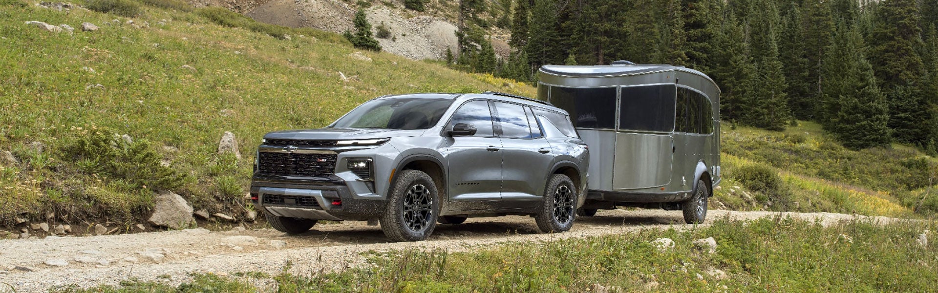 Chevrolet Traverse towing a trailer on a mountain trail.